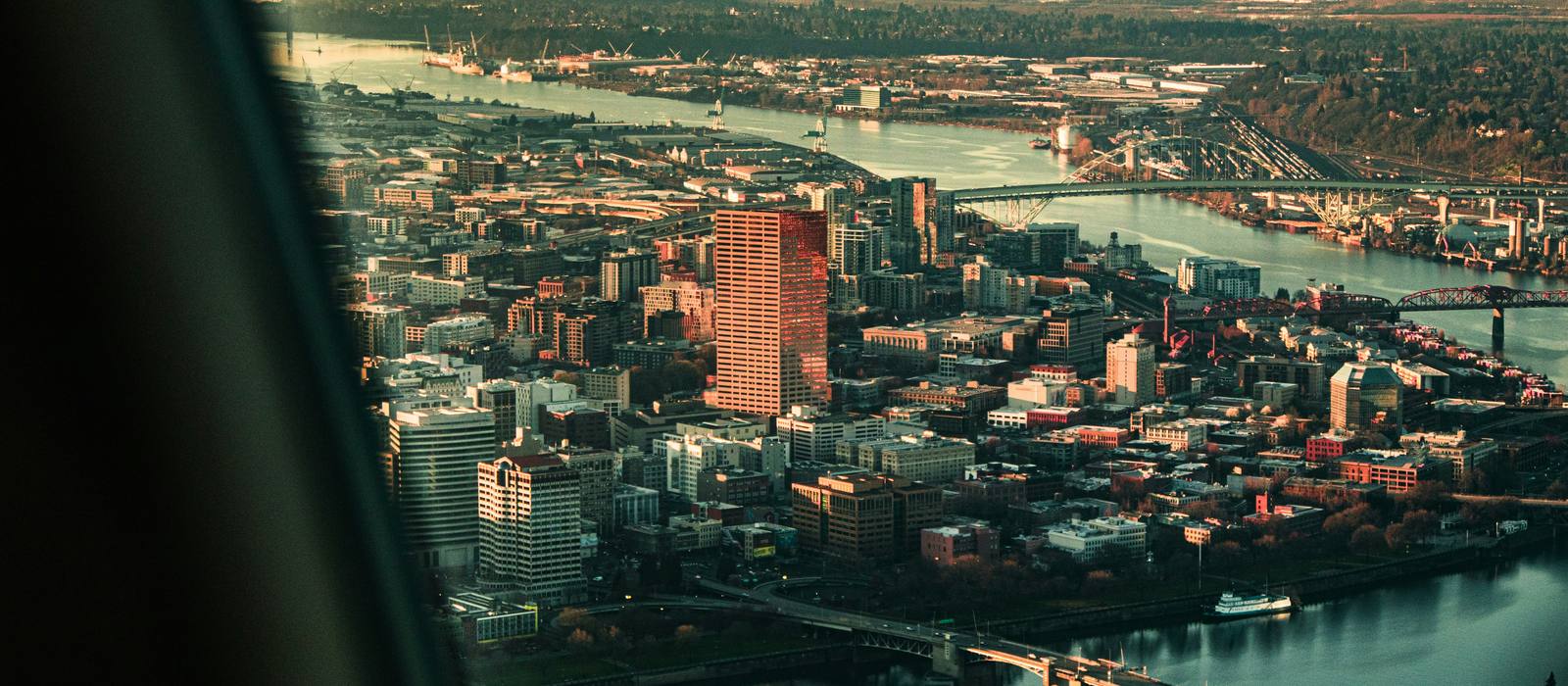 Portland from the air at dusk, the Willamette River and its bridges running through downtown